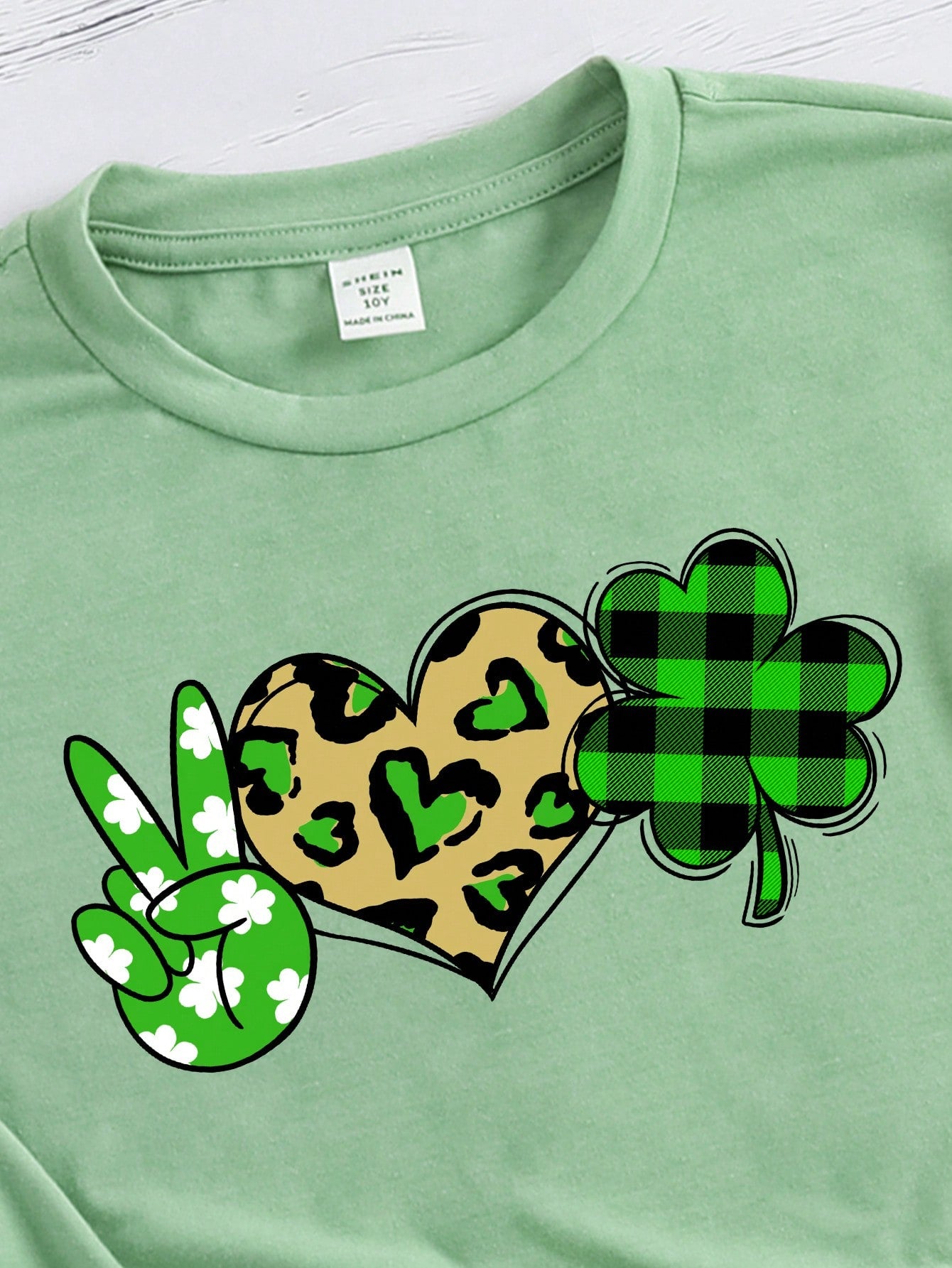 A casual short-sleeve t-shirt for tween girls featuring a simple and lucky clover pattern, perfect for the summer season.